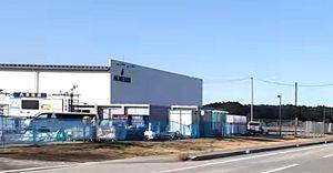 (株)アルメディオ【7859】 やっぱり写真を見ると、 コンテナ型設備約10台ほど サイズ：40ftクラス【12m x 2.35mX2.35m】 ぐらいはありそうに見えるんやけどな～　なんやねんこれ？　  泊り込みできる施設なのかもしれない？ 4カ所も緑の仮設トイレっぽいのが見えるし。 自販機っぽいのものあるし、 トイレ側から出てきた人が忘れ物したように戻るのが動画でみえる。  モニターっぽいのは、わりと薄くて、コンテナの手間にあるように見える。